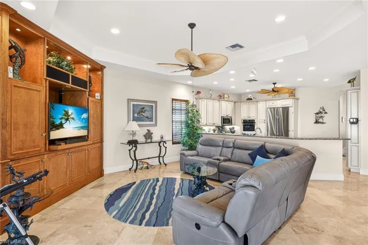 Family room with recessed lighting, ornamental molding, and a ceiling fan