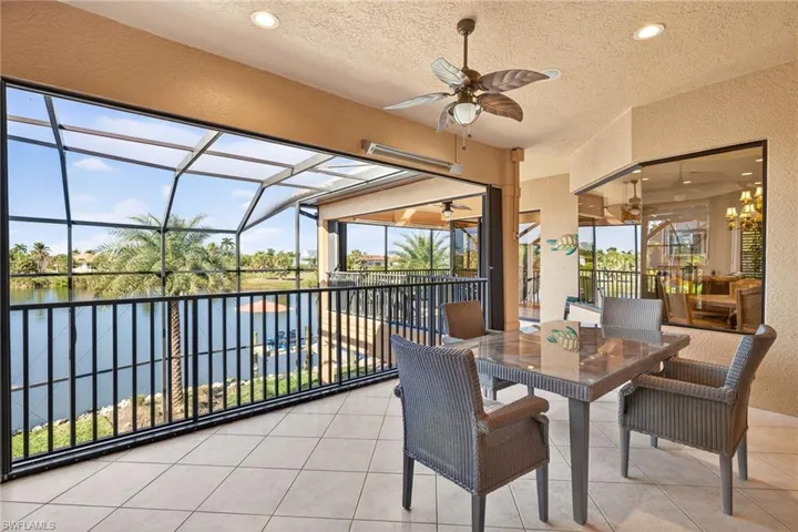 Sunroom / solarium with a water view, healthy amount of natural light, and a chandelier