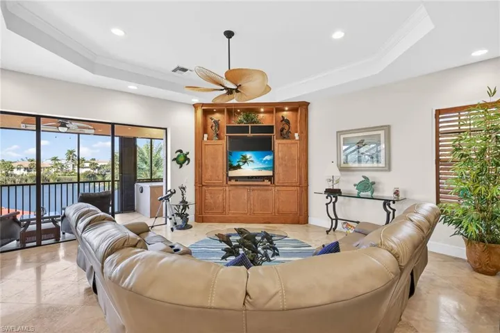 Family room featuring ornamental molding, a raised ceiling, recessed lighting, and a ceiling fan
