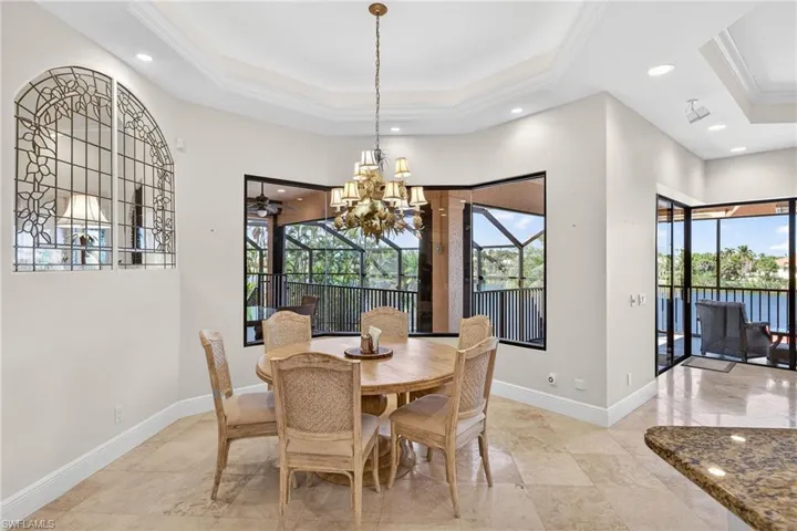 Breakfast area with a chandelier, ornamental molding, a tray ceiling, recessed lighting, and a sunroom