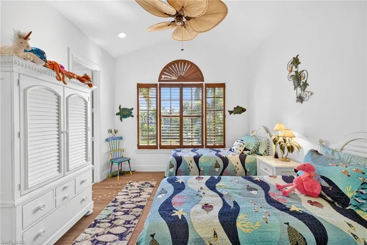 Bedroom with lofted ceiling, ceiling fan, wood finished floors, and recessed lighting