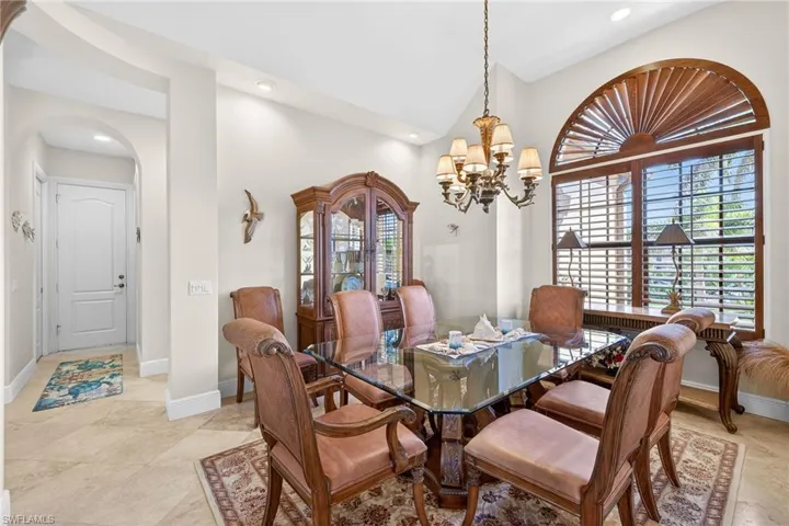 Dining room with a chandelier, recessed lighting, arched walkways, and vaulted ceiling