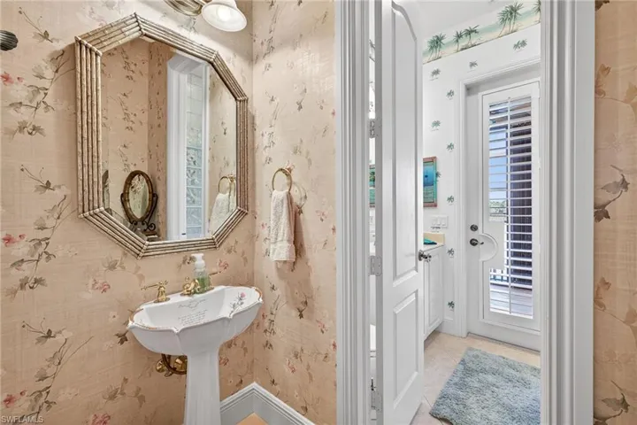 Bathroom with wallpapered walls and healthy amount of natural light