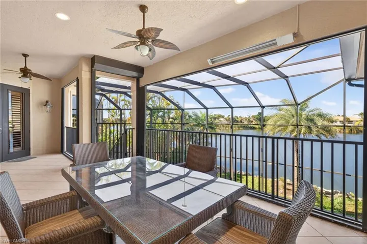 View of patio with ceiling fan, outdoor dining area, a sunroom, a lanai, and a water view