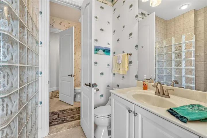 Bathroom featuring vanity, light tile patterned floors, and wallpapered walls