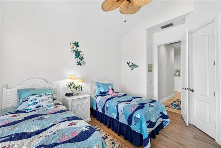 Bedroom with light wood-style flooring, lofted ceiling, and a ceiling fan
