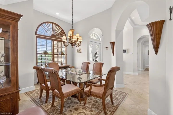 Dining room with arched walkways, a chandelier, and recessed lighting