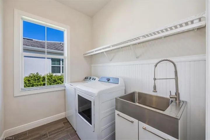 Laundry room has tub sink with upgraded wood shelving