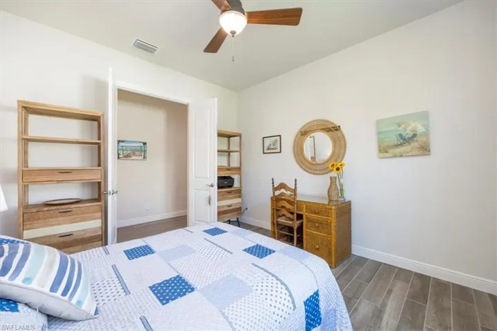 Den has a beautiful ceiling fan and wide wood-look tile flooring