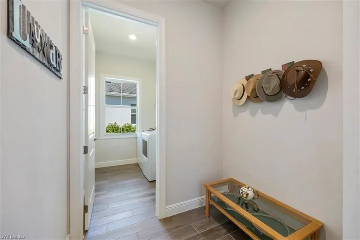 Hallway near the garage door entrance with future drop-zone area and entry into the laundry room