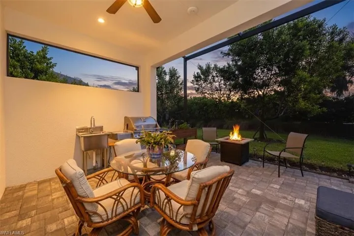 View of patio with outdoor dining area, ceiling fan and exterior kitchen
