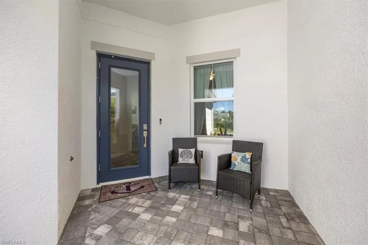 Front door entry with ample room for patio furniture. Both the window and door are hurricaine impact rated