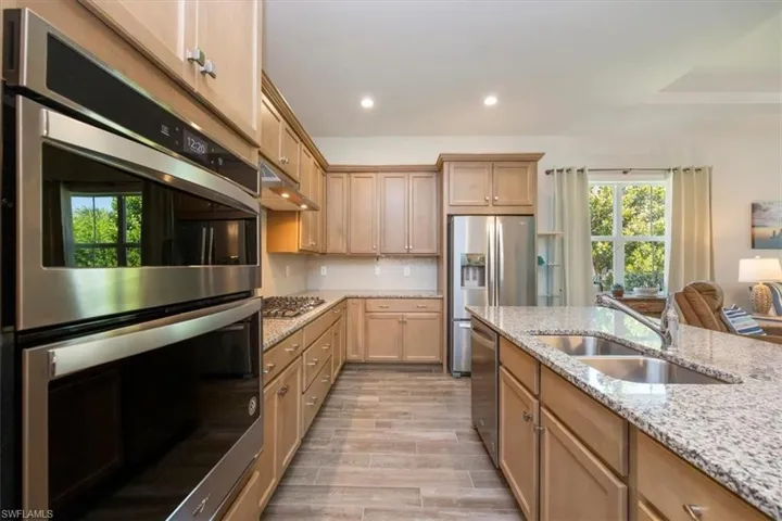 Gourmet kitchen has gas cooking, wall microwave and oven and stainless steel appliances