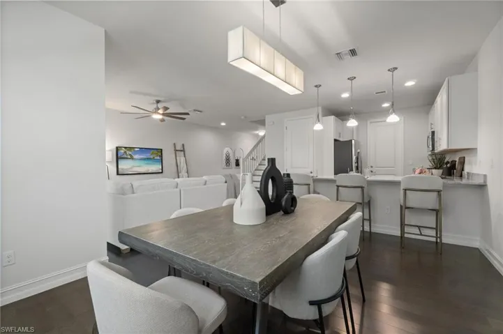 Dining space featuring dark wood-style floors, ceiling fan, and recessed lighting