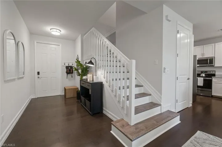 The welcoming entryway has a bright feel with contrasting, modern finishes in the warm flooring.