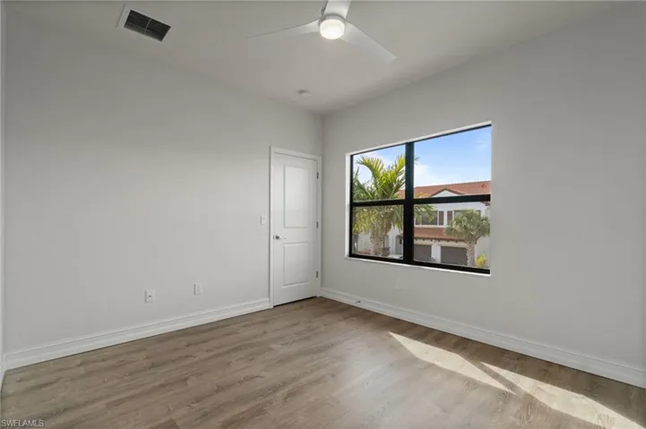 Empty room featuring light wood finished floors and a ceiling fan