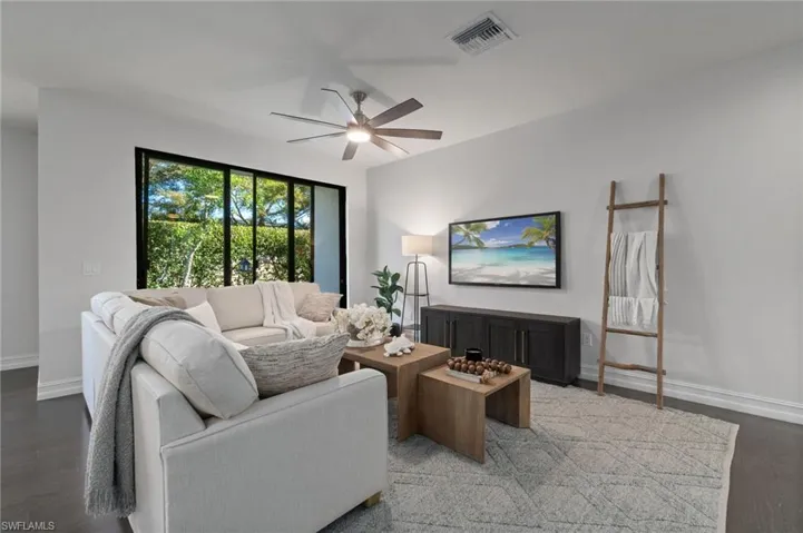 Open Living area with rich wood finished floors and a contrasting ceiling fan features A convenient and beautiful walk out 3 panel Slider to a private outdoor patio.