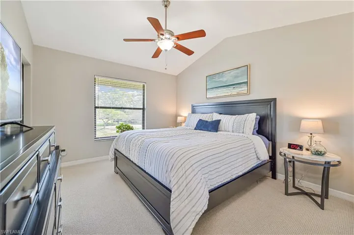 Primary bedroom with king bed, high ceilings and new carpet.