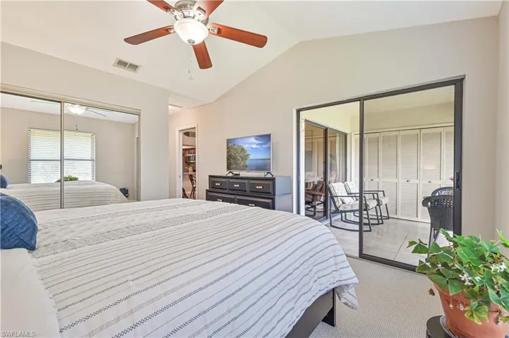 Primary bedroom has sliders to the lanai, high ceilings, and a large closet with sliding mirrowed doors.