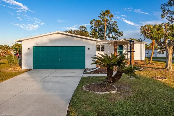 Ranch-style home with driveway, a front lawn, and an attached garage