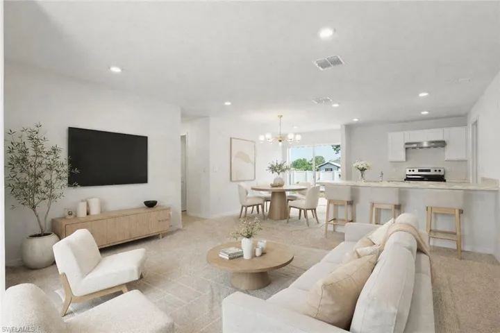 Living area with suspended lighting and light colored carpet