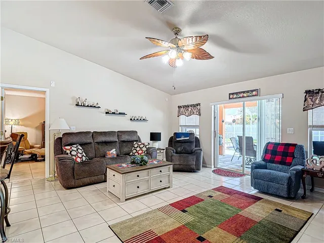 Living room featuring ceiling fan, a textured ceiling, and light tile floors