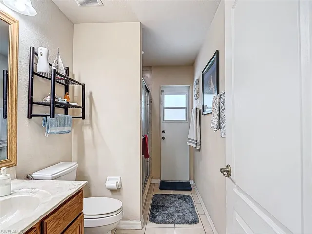 Bathroom featuring vanity, toilet, and tile floors
