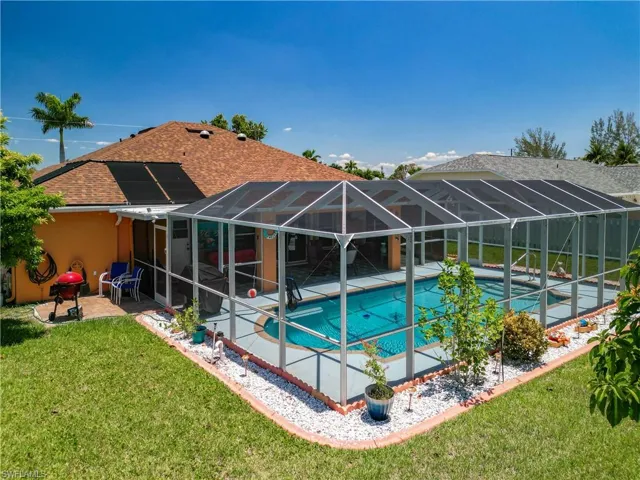View of pool with a patio, a lanai, area for grilling, and a lawn