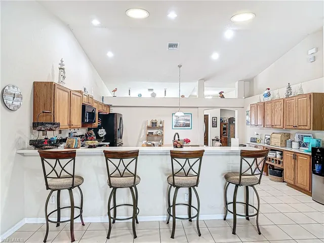 Kitchen featuring a kitchen bar, light tile floors, and kitchen peninsula