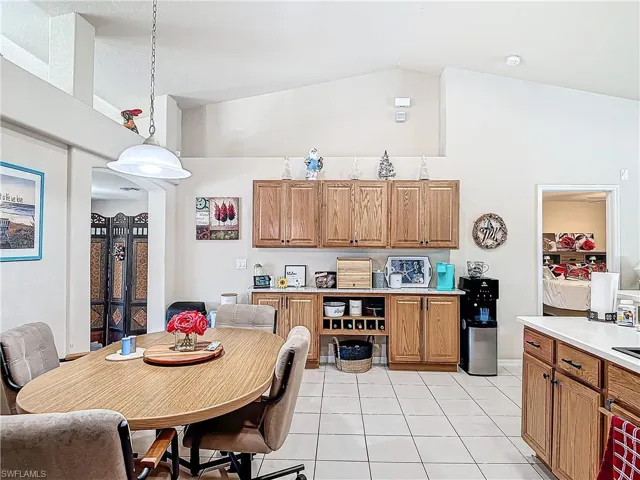 Kitchen featuring high vaulted ceiling, decorative light fixtures, and light tile floors