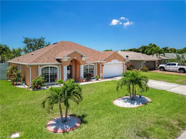 Single story home featuring a garage and a front lawn