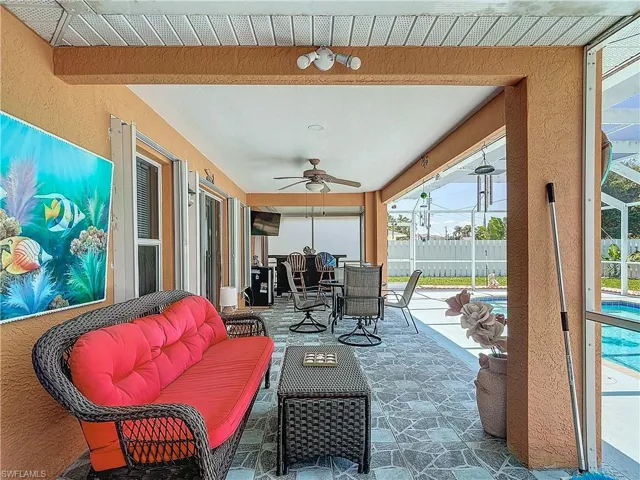 View of patio with an outdoor living space, ceiling fan.