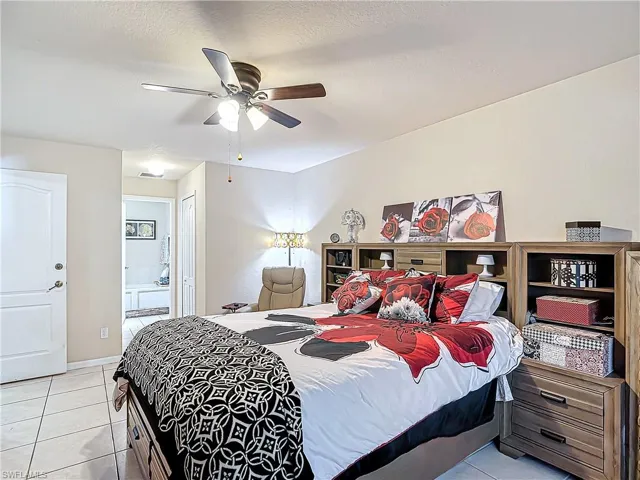 Main Tiled bedroom with ceiling fan, a closet, and ensuite bath