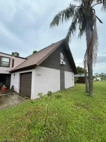 View of home's exterior featuring a lawn and a garage