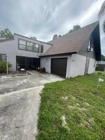 View of front of home featuring cooling unit and a front yard