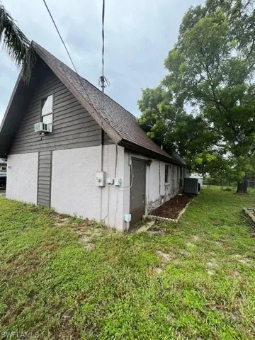 View of home's exterior with cooling unit, a yard, and central air condition unit