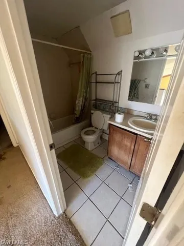 Full bathroom with tile patterned flooring, vanity, toilet, and shower / tub combo