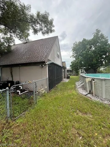 View of home's exterior featuring a sunroom and a yard