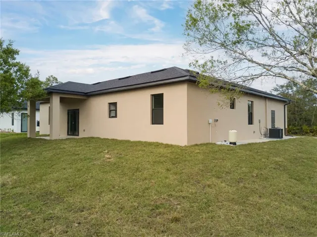 Rear view of property featuring a patio, stucco siding, and a yard