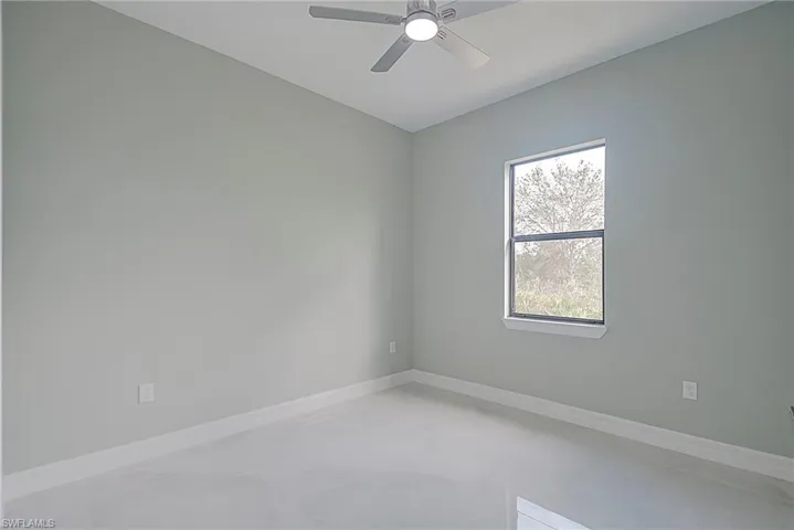 Unfurnished room featuring baseboards and ceiling fan