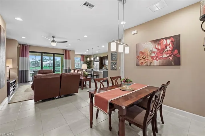 Formal dining with living room and kitchen in the background.