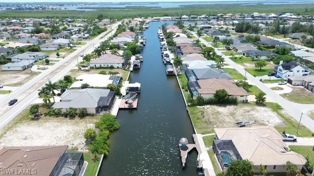 Waterfront property featuring canal access, private boat dock, and screened-in pool enclosure