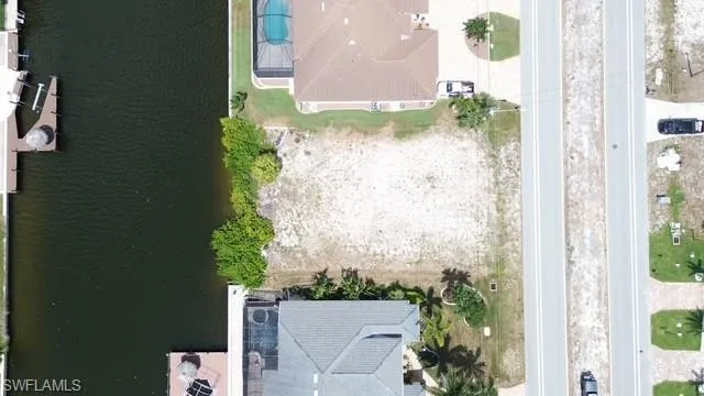 Cleared buildable lot featuring canal frontage with neighboring docks visible