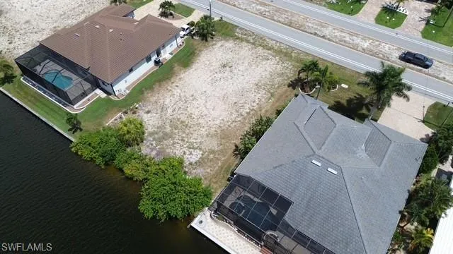 Expansive waterfront parcel featuring a natural shoreline, mature vegetation, and direct canal access