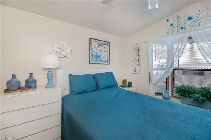 Bedroom featuring lofted ceiling, a textured ceiling, and ceiling fan
