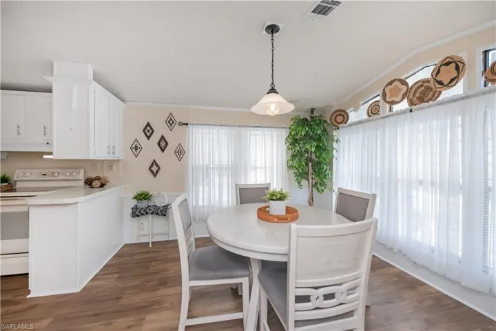 Dining room with dark wood finished floors and ornamental molding
