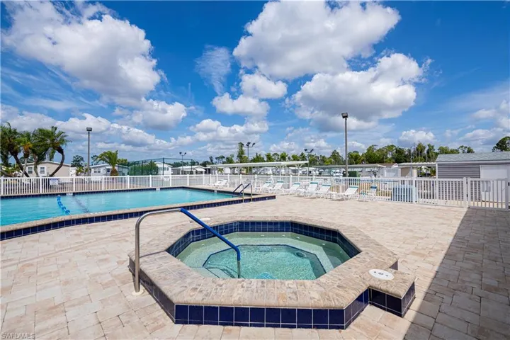Community pool featuring a patio and a hot tub