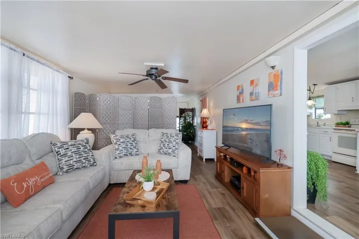 Living room with light wood-type flooring and ceiling fan