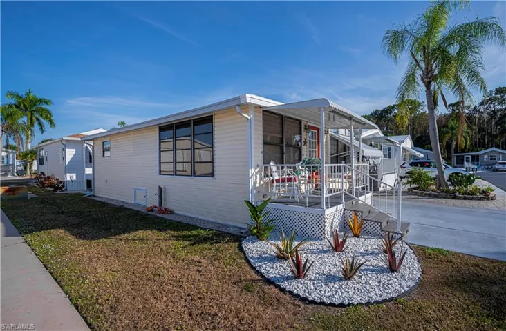 View of side of home with a lawn and a deck