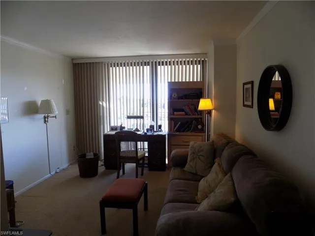 Living area with crown molding, carpet floors, and baseboards